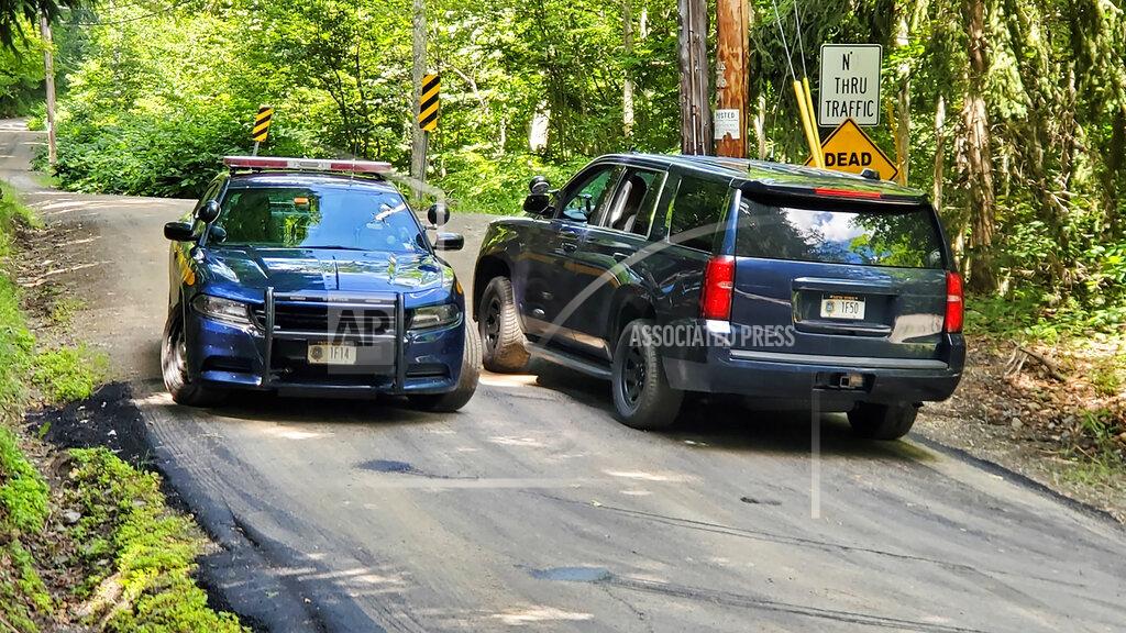 Jim Sabastian FILE - In this July 20, 2020, file photo, New York State Police block off a road near the scene where the body of Roy Den Hollander was found near Livingston Manor, N.Y. (Jim Sabastian/Times Herald-Record via AP, File)