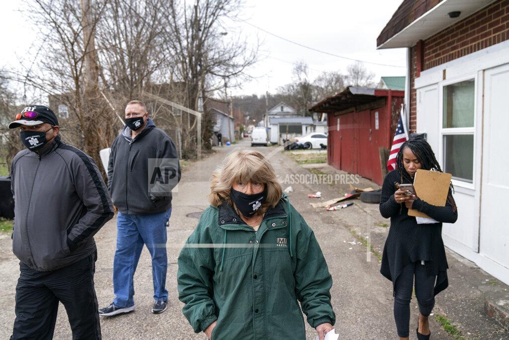 David Goldman Sue Howland, center, walks down a street to check on someone who overdosed days before with fellow members of the the Quick Response Team, from left, pastor Virgil Johnson, Sgt. Greg Moore and Larrecsa Cox, Monday, March 15, 2021, in Huntington, W.Va. Howland, the 62-year-old peer recovery coach, nearly drank herself to death. She's been sober now for 10 years. "We're going to love them until they learn to love themselves," said Howland of the people she tries to help. "We're going to love them back to life." (AP Photo/David Goldman)