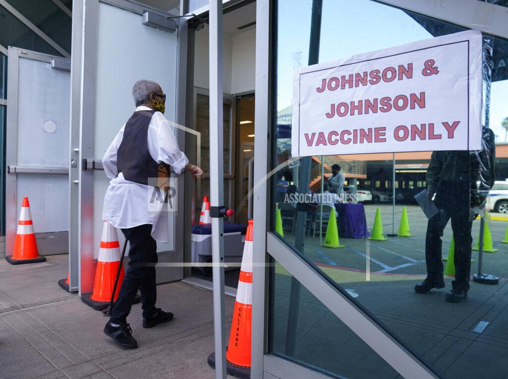 Damian Dovarganes FILE - In this April 1, 2021, file photo, people walk in to get their COVID-19 vaccine at the Baldwin Hills Crenshaw Plaza past a sign that says "Johnson & Johnson vaccine only" in Los Angeles. U.S. health regulators on Tuesday, April 13, is recommending a “pause” in using the vaccine to investigate reports of potentially dangerous blood clots. (AP Photo/Damian Dovarganes, File)