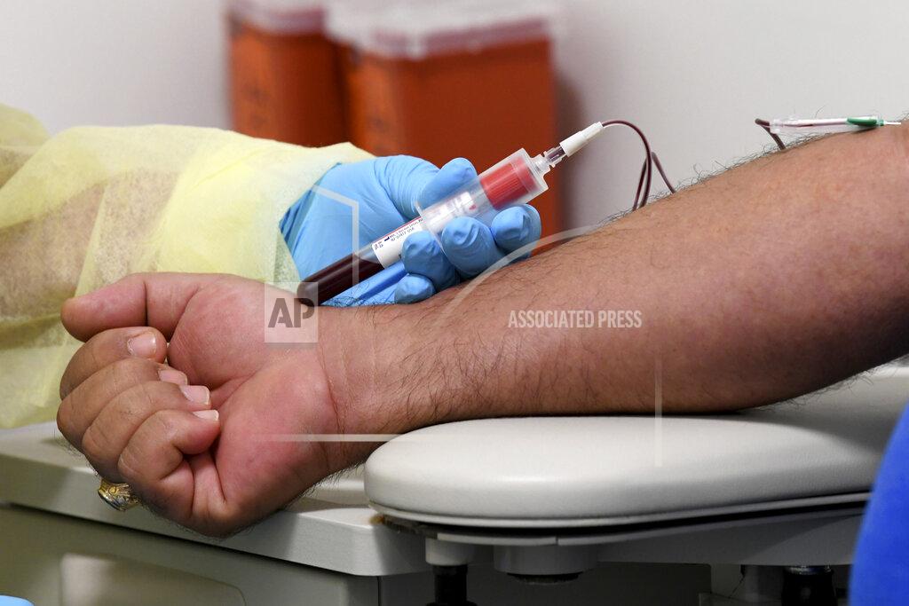 Taimy Alvarez University of Miami Miller School of Medicine phlebotomist Mayra Fernandez takes a blood sample from study participant Julio Li, Wednesday, Sept. 2, 2020, in Miami. Miami is one of 89 cities around the U.S. that's testing the Moderna COVID-19 vaccine. (AP Photo/Taimy Alvarez)