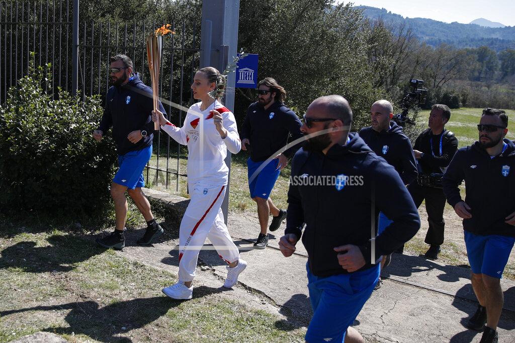 Thanassis Stavrakis Greek shooting Olympic champion Anna Korakaki, the first torchbearer, holds the torch following the flame lighting ceremony at the closed Ancient Olympia site, birthplace of the ancient Olympics in southern Greece, Thursday, March 12, 2020, 2020. Greek Olympic officials are holding a pared-down flame-lighting ceremony for the Tokyo Games due to concerns over the spread of the coronavirus. Both Wednesday's dress rehearsal and Thursday's lighting ceremony are closed to the public, while organizers have slashed the number of officials from the International Olympic Committee and the Tokyo Organizing Committee, as well as journalists at the flame-lighting. (AP Photo/Thanassis Stavrakis)