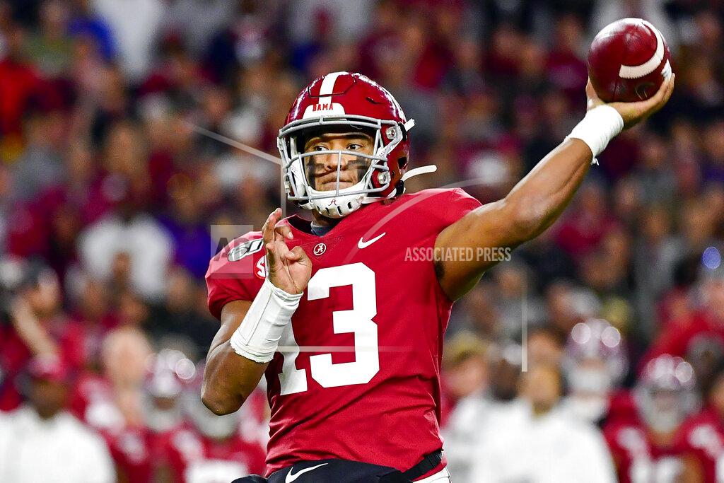FILE - In this Nov. 9, 2019, file photo, Alabama quarterback Tua Tagovailoa throws during an NCAA football game in Tuscaloosa, Ala. The rookie quarterback has reported to Miami Dolphins training camp and will practice without restrictions as he comes back from a knee injury and begins to compete to overtake veteran Ryan Fitzpatrick for the starting job. (AP Photo/Vasha Hunt, File)
