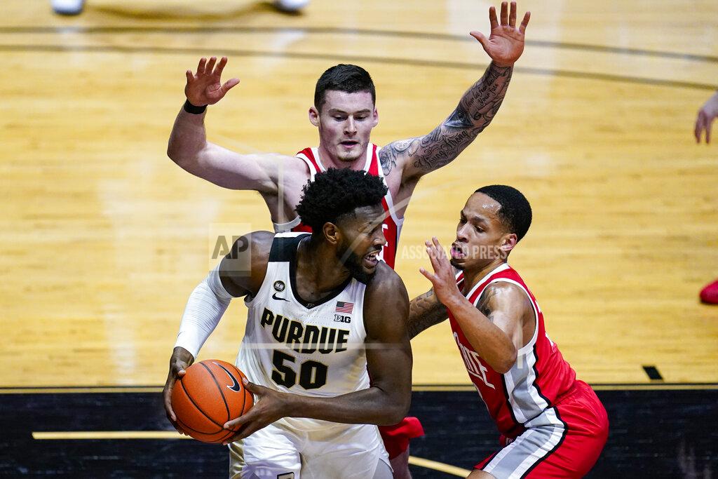 Michael Conroy Purdue forward Trevion Williams (50) is defended by Ohio State guard CJ Walker (13) and forward Kyle Young (25) during the second half of an NCAA college basketball game in West Lafayette, Ind., Wednesday, Dec. 16, 2020. (AP Photo/Michael Conroy)