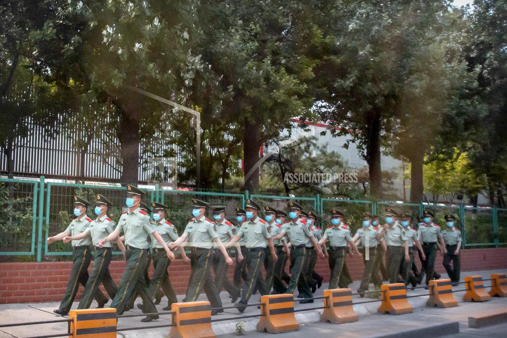 Mark Schiefelbein Chinese paramilitary police march in formation outside the Xinfadi wholesale food market district in Beijing, Saturday, June 13, 2020. Beijing closed the city's largest wholesale food market Saturday after the discovery of seven cases of the new coronavirus in the previous two days. (AP Photo/Mark Schiefelbein)