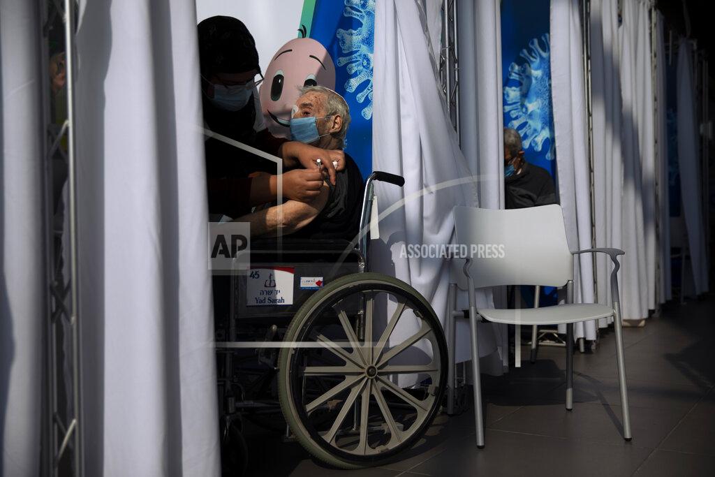 Oded Balilty A man receives a coronavirus vaccine from medical staff at a COVID-19 vaccination center in Tel Aviv, Israel, Tuesday, Jan. 5, 2021. With elections approaching in March, Israeli Prime Minister Benjamin Netanyahu has placed his world-leading vaccination drive at the center of his re-election campaign launching an aggressive media blitz portraying him as almost singlehandedly leading the country out of the pandemic. (AP Photo/Oded Balilty)