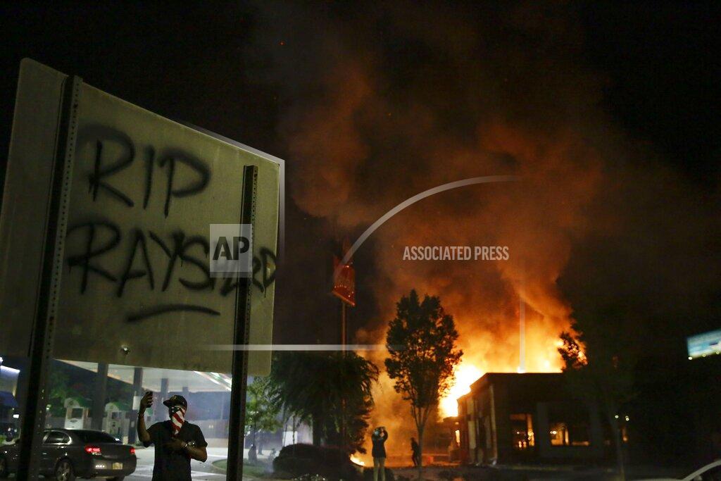 Brynn Anderson File-In this Saturday, June 13, 2020 file photo, "RIP Rayshard" is spray-painted on a sign as flames engulf a Wendy's restaurant where Rayshard Brooks was shot and killed by police in Atlanta. About five months before he was killed by Atlanta police in a Wendy's parking lot -- before his name and case would become the latest rallying point in a massive call for racial justice and equality nationwide – Brooks gave an interview to an advocacy group about his years of struggle in the criminal justice system. (AP Photo/Brynn Anderson, File)