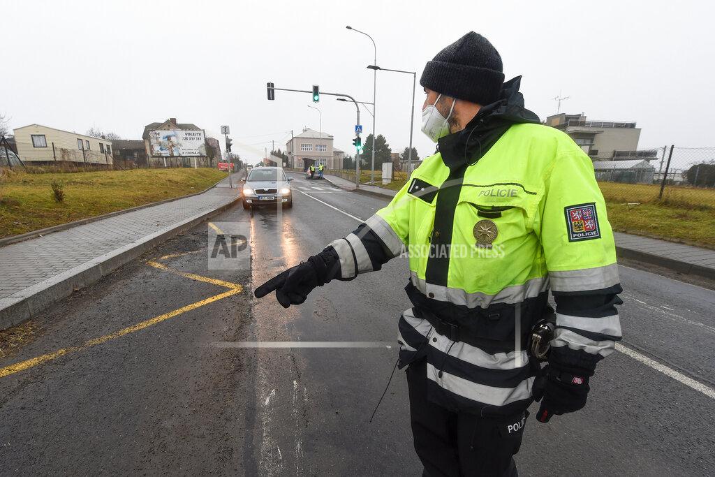 Jaroslav Ozana A police officer stops a car on a road between the towns, Ostrava and Opava, near Dehylov, Czech Republic Monday, March 1, 2021. Limits for free movement of people are set in the Czech Republic. Travelling to other counties unless the go to work or have to take care about relatives is prohibited. (Jaroslav Ozana/CTK via AP) ** SLOVAKIA OUT **