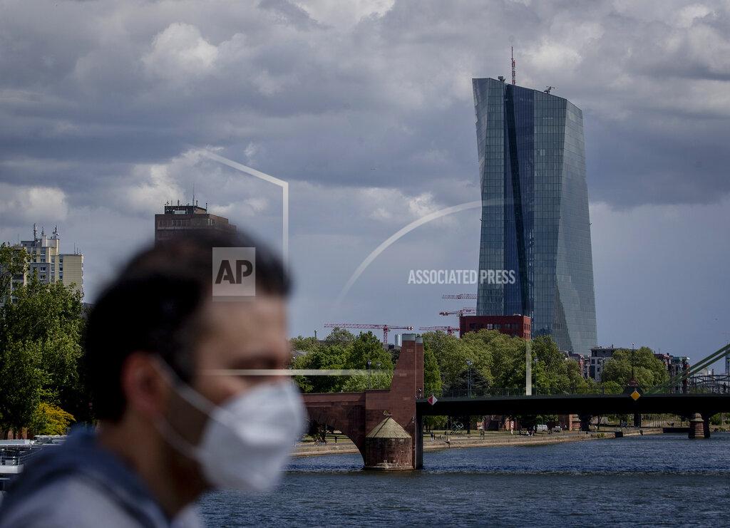 FILE - In this Wednesday, April 29, 2020 file photo, a man walks in front of the European Central Bank in Frankfurt, Germany. Official figures Tuesday Sept. 1, 2020, shows the unemployment rate across the 19 countries that use the euro currency rose modestly to 7.9% in July as the jobless spike was held down by temporary government job-support programs and the relaxation of some coronavirus containment measures. (AP Photo/Michael Probst, File)