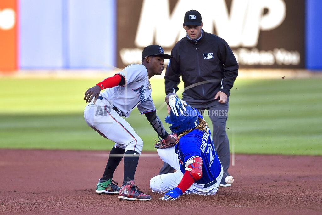 Adrian Kraus Toronto Blue Jays' Vladimir Guerrero Jr. slides safely into second for a double as Miami Marlins shortstop Jazz Chisholm Jr. (2) waits for the throw that bounced off Guerrero'a back during the first inning of a baseball game in Buffalo, N.Y., Tuesday, June 1, 2021. (AP Photo/Adrian Kraus)