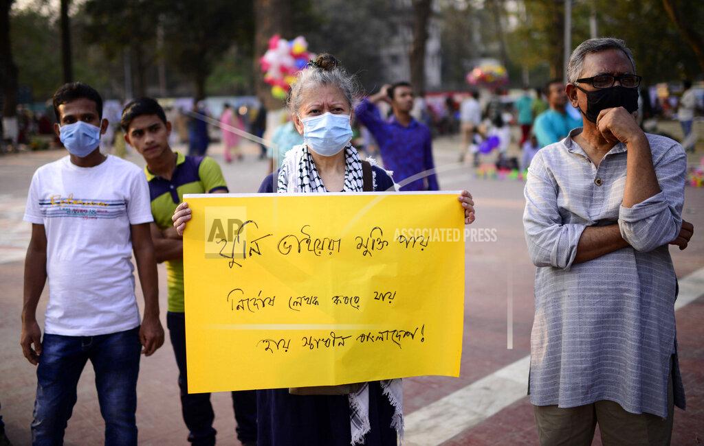 Mahmud Hossain Opu A woman holds a placard to protest the death in prison of a writer who was arrested on charges of violating the sweeping digital security, in Dhaka, Bangladesh, Friday, Feb. 26, 2021. Mushtaq Ahmed, 53, was arrested in Dhaka in May last year for making comments on social media that criticized the Prime Minister Sheikh Hasina government's handling of the coronavirus pandemic. He had been denied bail at least six times. Placrad reads "Murderer brothers get released. Innocent writer found place in a grave. Alas! Independent Bangladesh." (AP Photo/Mahmud Hossain Opu)