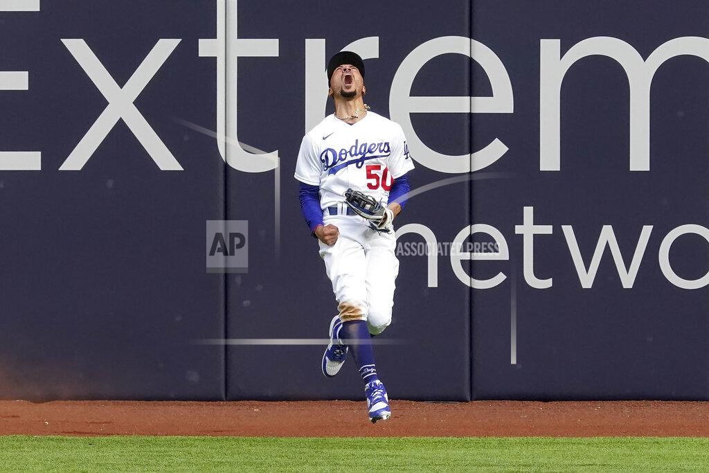 Tony Gutierrez Los Angeles Dodgers right fielder Mookie Betts celebrates after robbing Atlanta Braves' Marcell Ozuna of a home during the fifth inning in Game 6 of a baseball National League Championship Series Saturday, Oct. 17, 2020, in Arlington, Texas. (AP Photo/Tony Gutierrez)