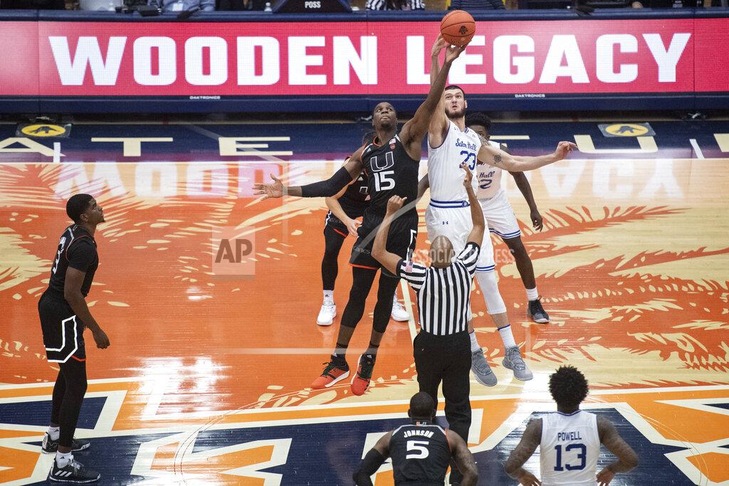 Kyusung Gong FILE - In this Nov. 25, 2018, file photo, Miami center Ebuka Izundu and Seton Hall forward Sandro Mamukelashvili leaps for the opening tip-off in an NCAA college basketball game in the final game of the Wooden Legacy tournament in Fullerton, Calif. The Wooden Legacy is back on for November with a tweaked format for the college basketball event that was canceled last year because of the coronavirus pandemic. Georgetown, Saint Joseph’s, San Diego State and Southern California will play Nov. 25 and 26 at the Anaheim Convention Center. (AP Photo/Kyusung Gong, File)
