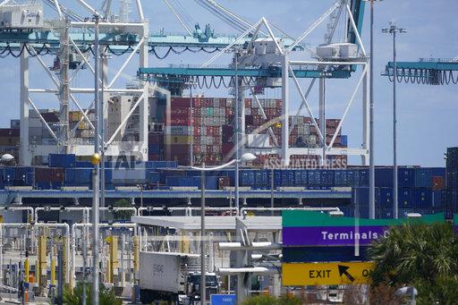In this April 9, 2021 photo, cargo containers are shown stacked near cranes at PortMiami in Miami. The U.S. trade deficit narrowed to $67.1 billion in October, after hitting a record high the previous month, as a big rebound in exports helped to offset a much smaller rise in imports. The October deficit was 17.6% below the September record of $81.4 billion, the Commerce Department reported Tuesday, Dec. 7, 2021. (AP Photo/Wilfredo Lee, file)