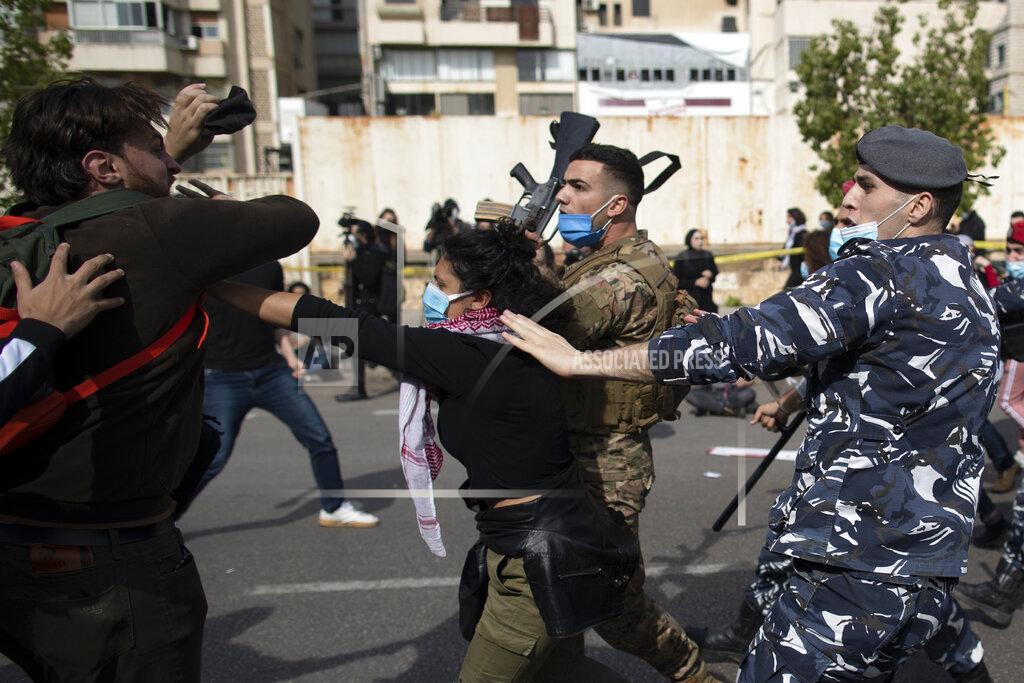 Hassan Ammar Riot police and army soldiers scuffle with anti-government protesters outside a military court in Beirut, Lebanon, Monday, Feb. 8, 2021. Riot police briefly clashed Monday in Beirut with hundreds of protesters demanding the release of anti-government activists detained following riots in northern Lebanon late last month. (AP Photo/Hassan Ammar)