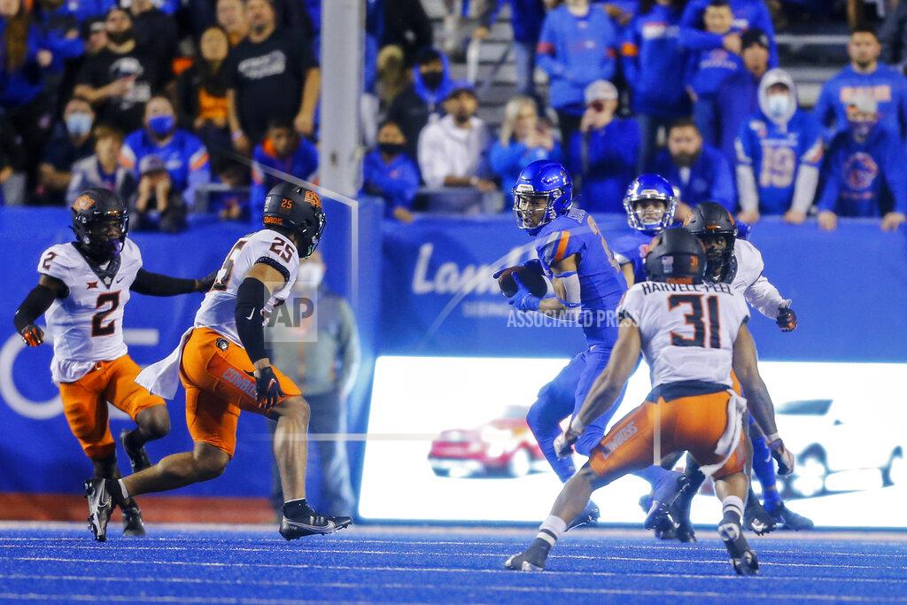 Steve Conner Boise State wide receiver Khalil Shakir (2) turns after a reception in front of Oklahoma State safety Jason Taylor II (25) and safety Kolby Harvell-Peel (31) during the second half of an NCAA college football game Saturday, Sept. 18, 2021, in Boise, Idaho. (AP Photo/Steve Conner)