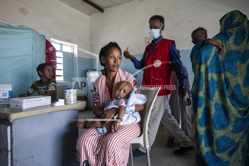 Nariman El-Mofty Surgeon and doctor-turned-refugee, Dr. Tewodros Tefera, prepares to preform a medical checkup on an infant, inside the Sudanese Red Crescent clinic in Hamdayet, eastern Sudan, near the border with Ethiopia, on March 22, 2021. (AP Photo/Nariman El-Mofty)