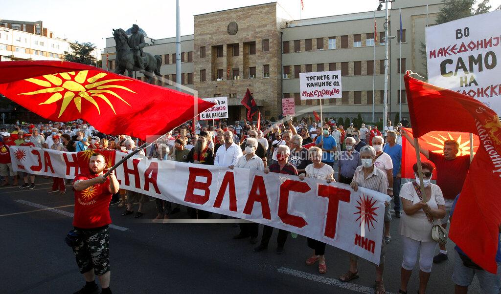 Boris Grdanoski People wave the old national flags and carry banners with patriotic slogans protesting the change of the country's name to North Macedonia and "disparage" of the Macedonian national identity and dignity in a process of country's Euro-Atlantic integration, in front of the parliament building in Skopje, North Macedonia, Sunday, Aug. 30, 2020. North Macedonia’s parliament continued its debate on a vote of confidence for a new left-wing coalition government after the Social Democrats and their ethnic Albanian partners secured a majority in parliament in July's general election. (AP Photo/Boris Grdanoski)