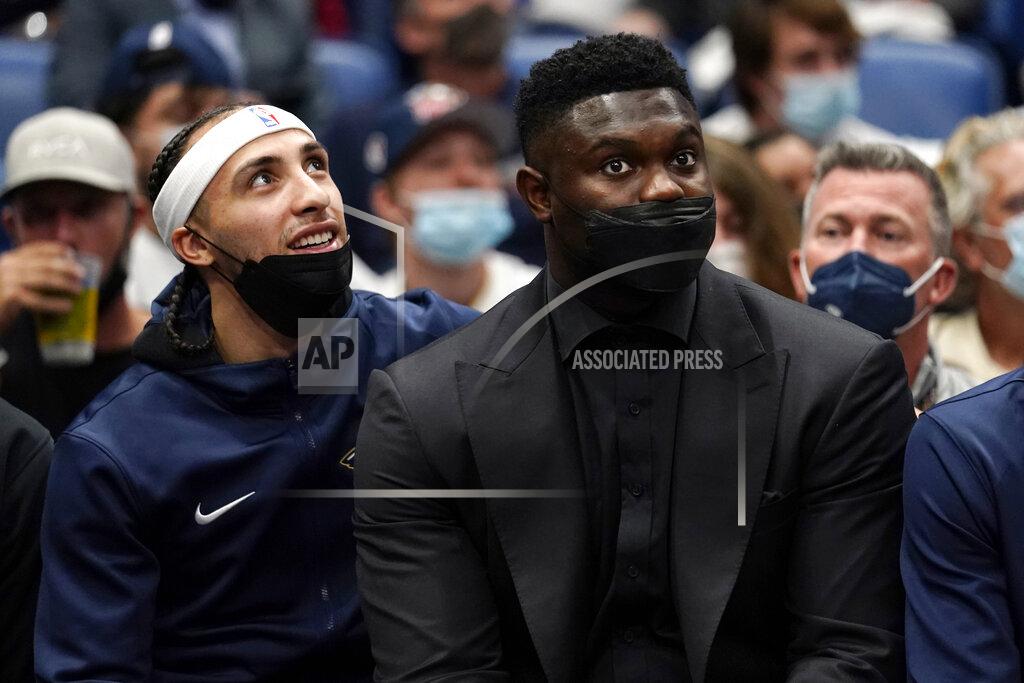 Gerald Herbert New Orleans Pelicans forward Zion Williamson, right, sits on the bench in street clothes with guard Jose Alvarado in the second half of an NBA basketball game against the Philadelphia 76ers in New Orleans, Wednesday, Oct. 20, 2021. The 76ers won 117-97. (AP Photo/Gerald Herbert)