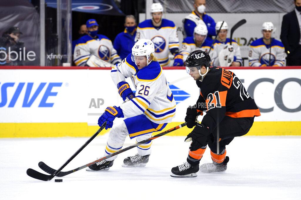 Derik Hamilton Buffalo Sabres' Rasmus Dahlin, left, plays the puck ahead of Philadelphia Flyers' Scott Laughton during the first period of an NHL hockey game, Sunday, April 11, 2021, in Philadelphia. (AP Photo/Derik Hamilton)
