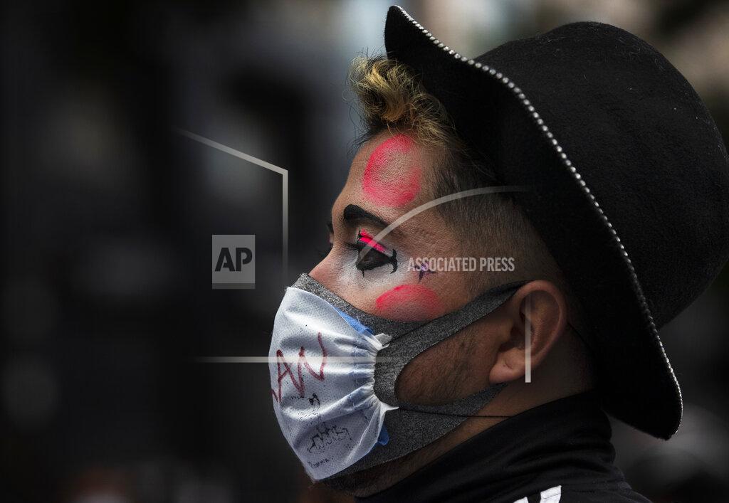 Marco Ugarte A clown joins a protest outside the Fine Arts Palace to demand financial aid amid the economic slowdown brought by partial lockdowns to contain the spread of COVID-19 in Mexico City, Tuesday, Aug. 11, 2020. The National Artistic Resistance (RAN) organization is asking the government for artists to be included in rescue budgets and given social support. (AP Photo/Marco Ugarte)