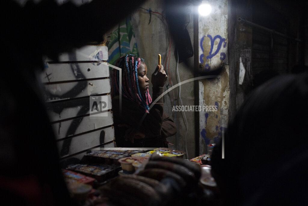 A girl takes photos of a protest a day after a deadly police operation in the Jacarezinho favela of Rio de Janeiro, Brazil, Friday, May 7, 2021. A bloody, hours-long gun battle here echoed into Friday, with authorities saying the police mission killed two dozen criminals while residents and activists claimed human rights abuses. (AP Photo/Silvia Izquierdo)