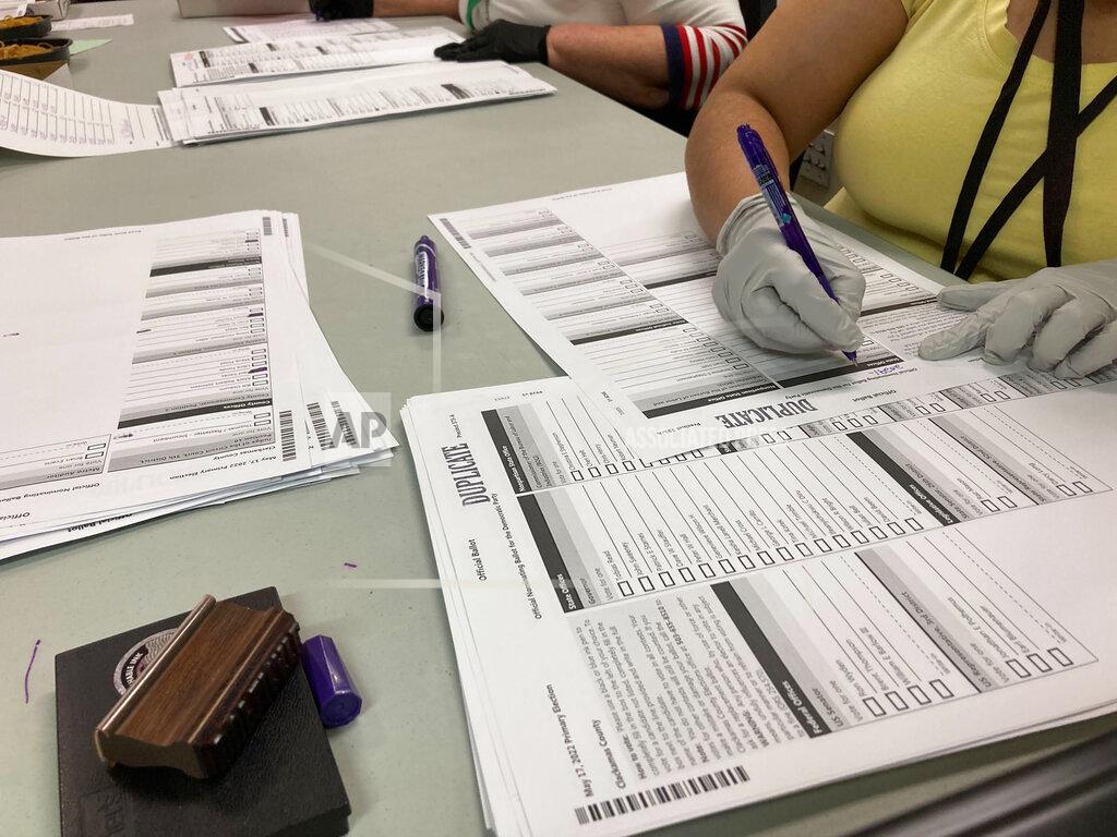 Gillian Flaccus Workers check ballots at elections offices in Clackamas County, Oregon, the state's third most populous county south of Portland, Tuesday, May 17, 2022. Many ballots in the county were printed with blurry barcodes, preventing them from being read by voting tabulation machines. Workers, one Democrat and one Republican per pair, are re-recording votes from the blurred ballots on new ballots so they can be read. The problem may cause significant delays in vote-counting in a county that includes parts of two Congressional districts, including one with a competitive Democratic primary. (AP Photo/Gillian Flaccus)