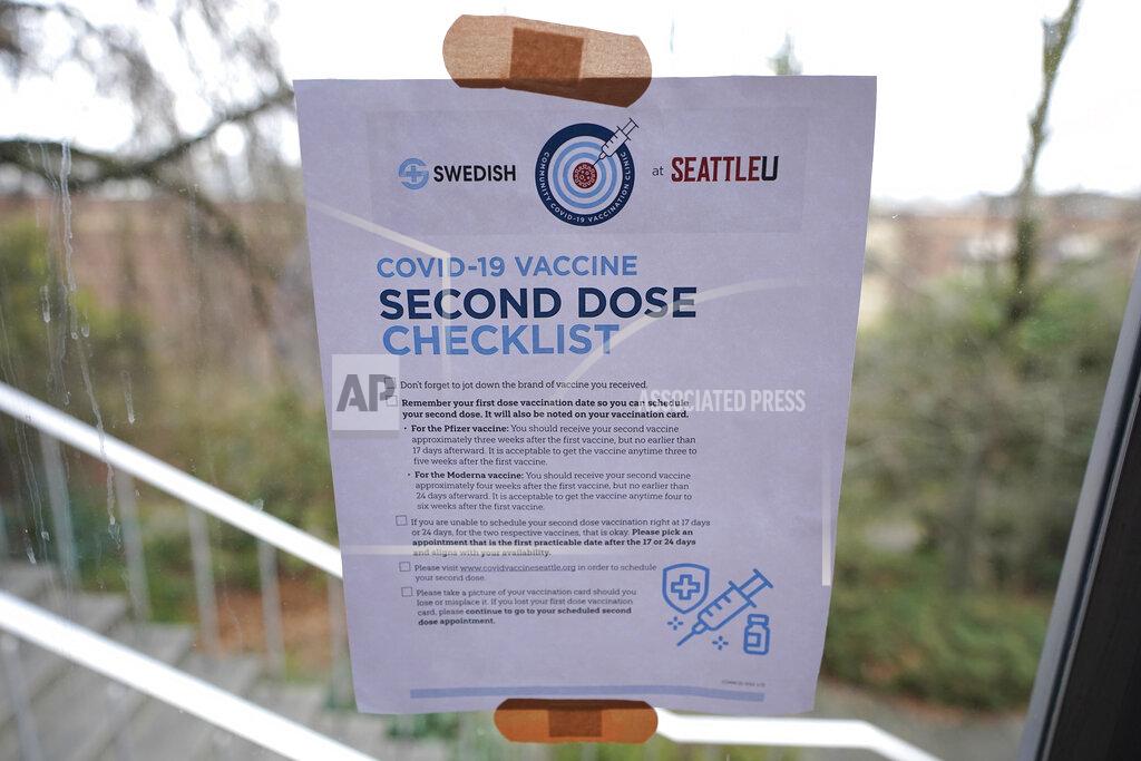 Ted S. Warren A checklist for people receiving the second dose of the Moderna or Pfizer COVID-19 vaccines is held to a window with adhesive bandages at a mass vaccination clinic at Seattle University, Friday, Feb. 26, 2021, in Seattle. As states ramp up vaccination distribution in the fight against the coronavirus, volunteers are needed to do everything from direct traffic to check people in to keep vaccination sites running smoothly. In return for their work, they're often given a shot — including those who are young and healthy and may not have otherwise been able to receive the shot until later in the year. (AP Photo/Ted S. Warren)