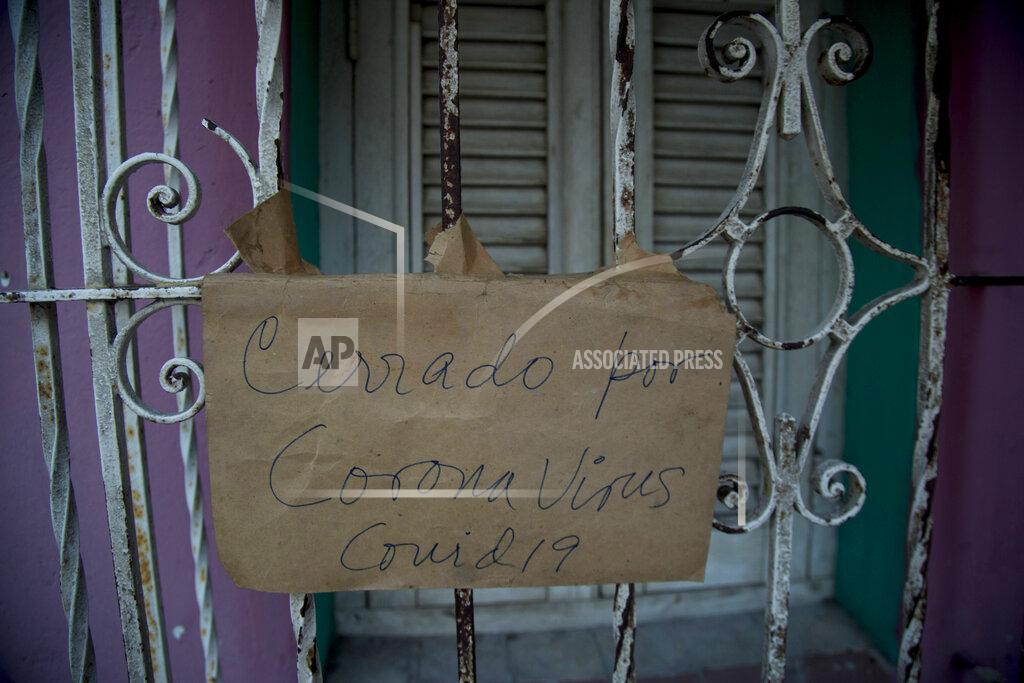 Ismael Francisco The Spanish message “Closed because of coronavirus COVID-19 hangs on the door of a business in Havana, Cuba, Friday, April 24, 2020. (AP Photo/Ismael Francisco)
