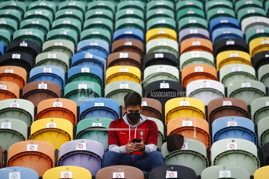 Armando Franca A young man wearing a face mask takes a seat marked as available to watch a soccer match between Portugal and Sweden at the Jose Alvalade stadium in Lisbon, Portugal, Wednesday, Oct. 14, 2020. Five thousand spectators were allowed on the stands but starting Wednesday at midnight, and for the upcoming two weeks, a maximum of five people will be allowed together either indoors or outdoors in public spaces and establishments such as restaurants due to a steady increase in cases of COVID-19 in the past weeks. (AP Photo/Armando Franca)