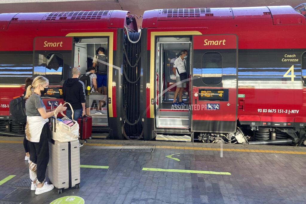 Karl Ritter Passengers, including American tourist Riley Smith, left, board a high-speed train to to Rome, Naples and Reggio Calabria in southern Italy from Florence's Santa Maria Novella train station, Italy, Wednesday, Sept. 1, 2021. The Italian government vowed to crack down on demonstrators threatening to block train tracks throughout the country on Wednesday as a rule requiring COVID-19 tests or vaccines takes effect for long-distance domestic public transport. (AP Photo/Karl Ritter)