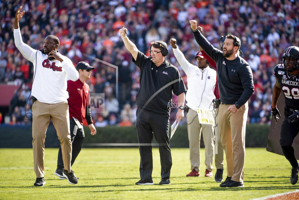 Sean Rayford South Carolina head coach Will Muschamp, center, John Scott, left, and Coleman Hutzler, signal to players during the first half of an NCAA college football game against Clemson, Saturday, Nov. 30, 2019, in Columbia, S.C. (AP Photo/Sean Rayford)
