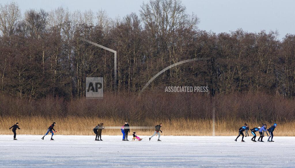 Peter Dejong A skater pulls a sled with a child on Nannewiid Lake in Oudehaske, Netherlands, Friday, Feb. 12, 2021. With many lakes and canals in the Netherlands frozen over, Dutch skating fans flocked to the ice Friday, causing a headache for authorities trying to enforce social distancing measures to stop the spread of the coronavirus. (AP Photo/Peter Dejong)