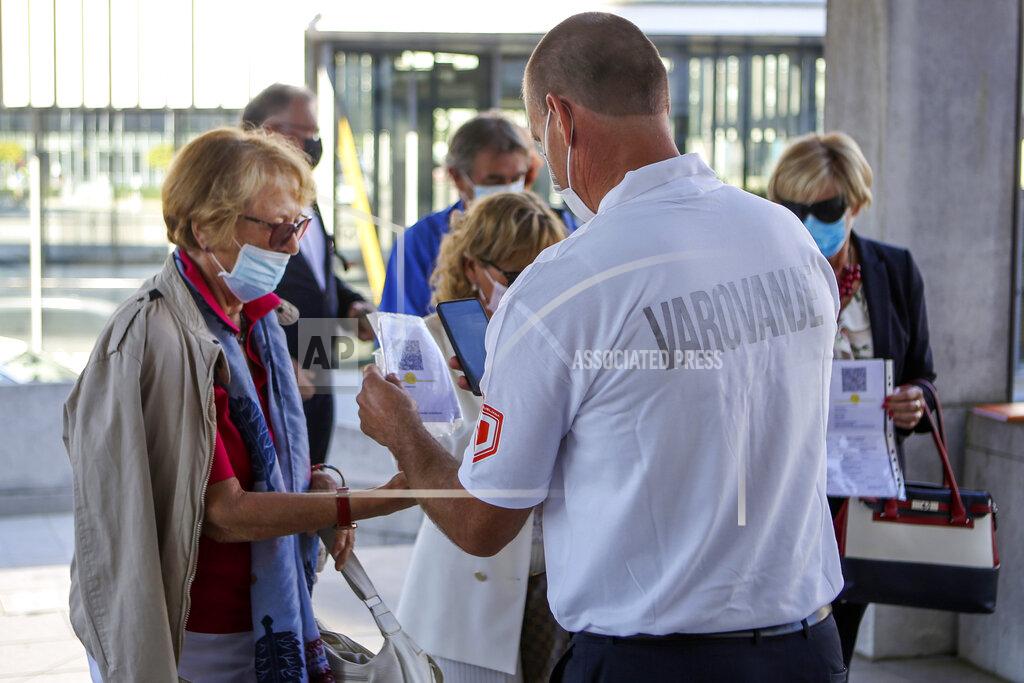 Uncredited A security person scans COVID-19 certificates of attendees of a political party gathering in Ljubljana, Friday, Sept. 10, 2021. Slovenia has introduced a mandatory anti-COVID vaccination for all civil service employees, further tightening anti-coronavirus measures that have triggered a major riot in the small Alpine state. The measure passed Friday Sept. 17, 2021 says that all state administration employees will need to be vaccinated with one shot by Oct. 1 and by Nov. 1 with the second, unless it's the one-dose Johnson & Johnson vaccine. (AP Photo)