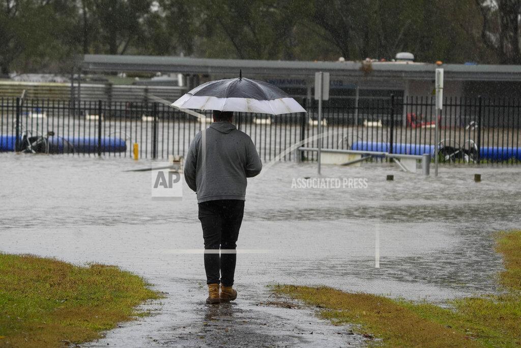 Mark Baker A man looks at a flooded sports venue in Camden on the outskirts of Sydney, Australia, Monday, July 4, 2022. More than 30,000 residents of Sydney and its surrounds have been told to evacuate or prepare to abandon their homes on Monday as Australia’s largest city braces for what could be its worst flooding in 18 months. (AP Photo/Mark Baker)