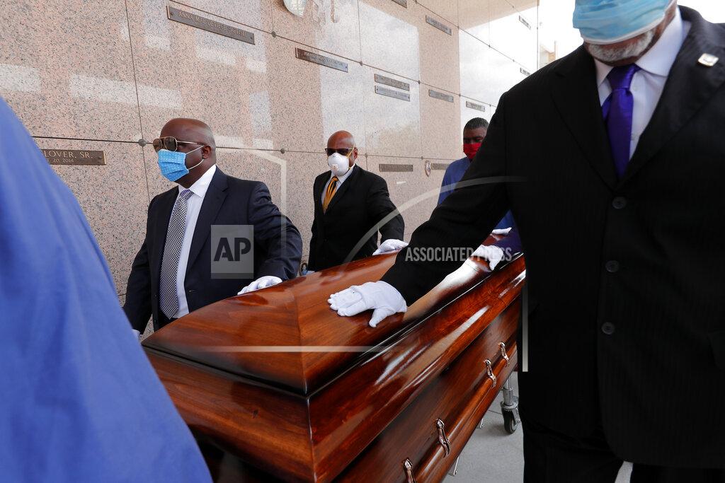 Gerald Herbert FILE - In this April 22, 2020, file photo, pallbearers, who were among only 10 allowed mourners, walk the casket for internment at the funeral for Larry Hammond, who died from the coronavirus, at Mount Olivet Cemetery in New Orleans. Hammond was Mardi Gras royalty, and would have had hundreds of people marching behind his casket in second-line parades. (AP Photo/Gerald Herbert, File)