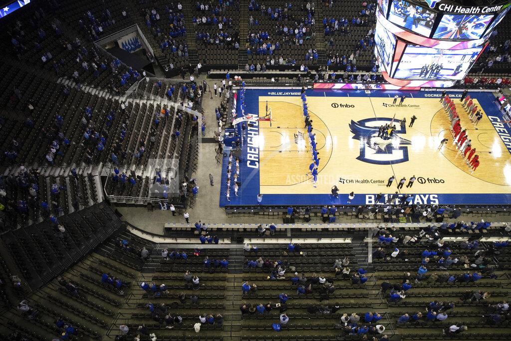 Rebecca S. Gratz With plenty of empty seats remaining, fans watch as St. John's and Creighton teams stand for the singing of the national anthem before playing in an NCAA college basketball game Wednesday, Jan. 19, 2022, in Omaha, Neb. (AP Photo/Rebecca S. Gratz)