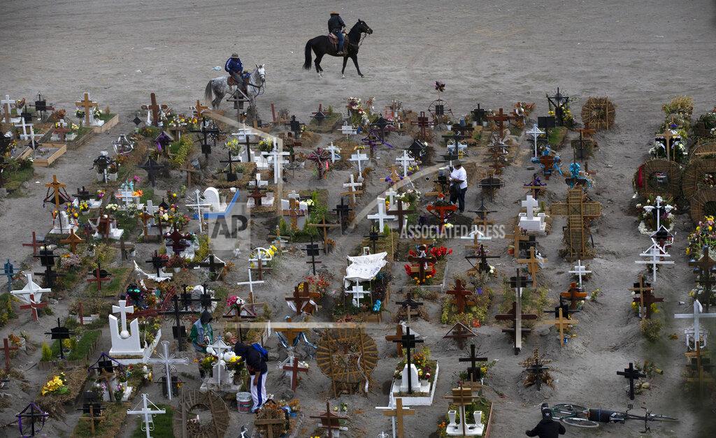 Marco Ugarte FILE - In this Nov. 18, 2020 file photo, workers ride their horses in the Valle de Chalco municipal cemetery, mostly reserved for those who have died from the coronavirus, on the outskirts of Mexico City. As Mexico approaches 200,000 in officially test-confirmed deaths from COVID-19, the real death toll is probably higher due to the country’s extremely low rate of testing. (AP Photo/Marco Ugarte, File)