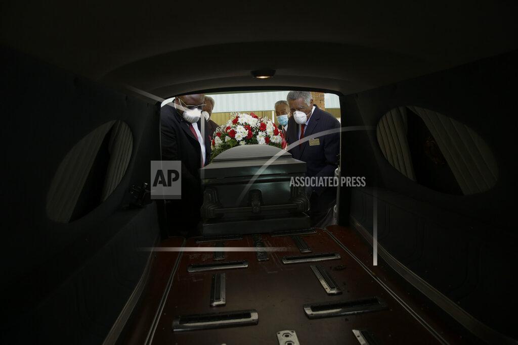 Brynn Anderson FILE - In this April 18, 2020 file photo, mortician Cordarial O. Holloway, foreground left, funeral director Robert L. Albritten, foreground right, and funeral attendants Eddie Keith, background left, and Ronald Costello place a casket into a hearse in Dawson, Ga. Across the county, the latest Associated Press analysis of available state and local data shows that nearly one-third of those who have died from COVID-19 are African American, with black people representing about 14% of the population in the areas covered. (AP Photo/Brynn Anderson)