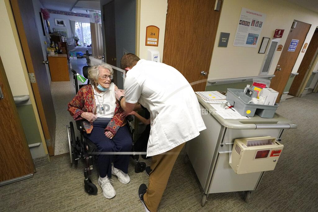 Ted S. Warren FILE - In this Jan. 8, 2021, file photo, Jean Allen, 96, left, receives the first shot of the Pfizer vaccination for COVID-19, from a Walgreens Pharmacist, right, at Queen Anne Healthcare, a skilled nursing and rehabilitation facility in Seattle. Allen survived catching COVID-19 before she was vaccinated, during a 2020 outbreak of COVID-19 that killed more than a dozen residents and two staff members. (AP Photo/Ted S. Warren, File)