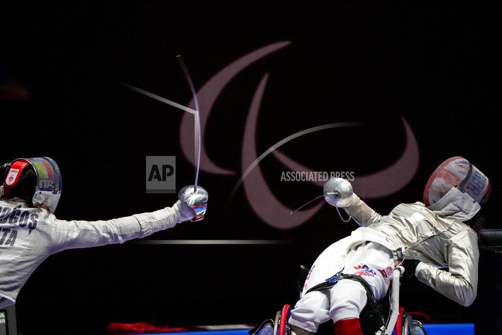 FILE - In this Aug. 25, 2021 file photo, Britain's Gemma Collins-McCann, right, defends against Italy's Ionela Andreea Mogos in women's saber individual, category A preliminary wheelchair fencing at the Tokyo 2020 Paralympic Games in Chiba, Japan. There are 4,403 Paralympic athletes competing in Tokyo, each with unique differences that have to be classified. Lines have to be draw, in the quest for fairness, to group similar impairments, or impairments that yield similar results. (AP Photo/Kiichiro Sato, File)