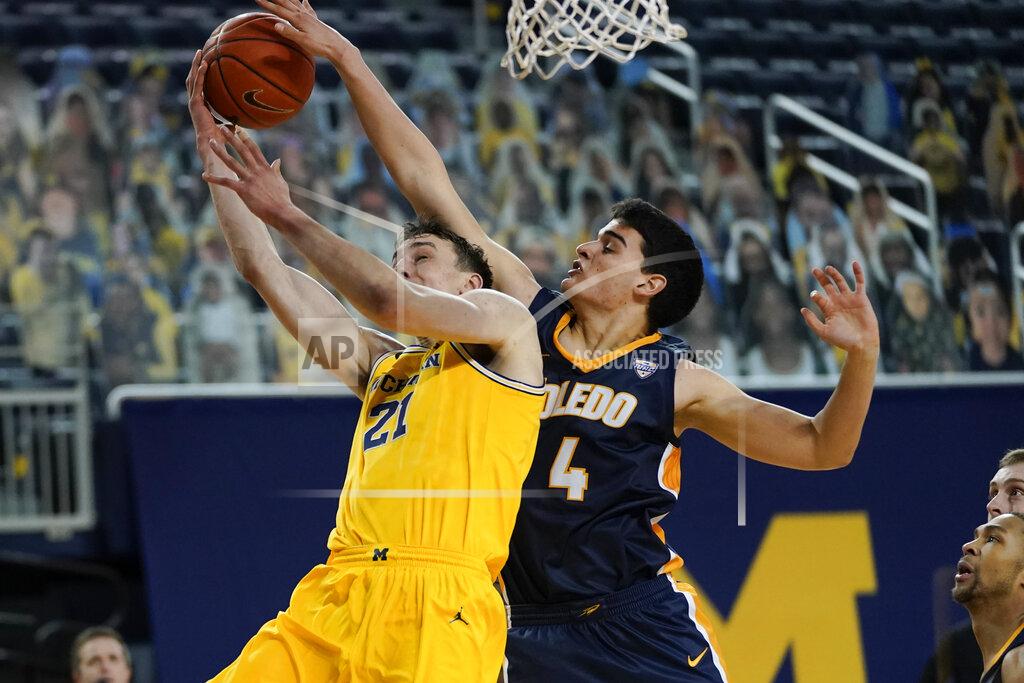 Paul Sancya Toledo forward Mattia Acunzo (4) blocks a Michigan guard Franz Wagner (21) shot in the second half of an NCAA college basketball game in Ann Arbor, Mich., Wednesday, Dec. 9, 2020. (AP Photo/Paul Sancya)
