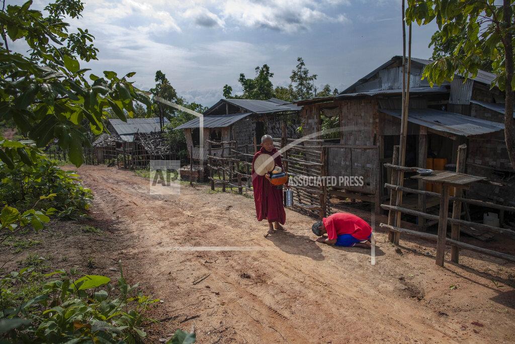 Gemunu Amarasinghe Zin Ko Ko Htwe, who was trafficked twice, bows after offering alms to a Buddhist monk outside his mother's house in Myawaddy, Myanmar, Friday, June 14, 2019. Ko Htwe said after escaping from a fishing boat in 2008, he was sold onto a palm oil plantation run by a police officer in Malaysia. When Americans and Europeans see palm oil is listed as an ingredient in their snacks, they should know "it's the same as consuming our sweat and blood," he says. (AP Photo/Gemunu Amarasinghe)