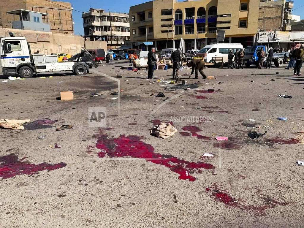 Ali Abdul Hassan Security forces work at the site of a deadly bomb attack in a market selling used clothes, Iraq, Thursday, Jan. 21, 2021. Twin suicide bombings hit Iraq's capital Thursday killing and wounding civilians, police and state TV said.