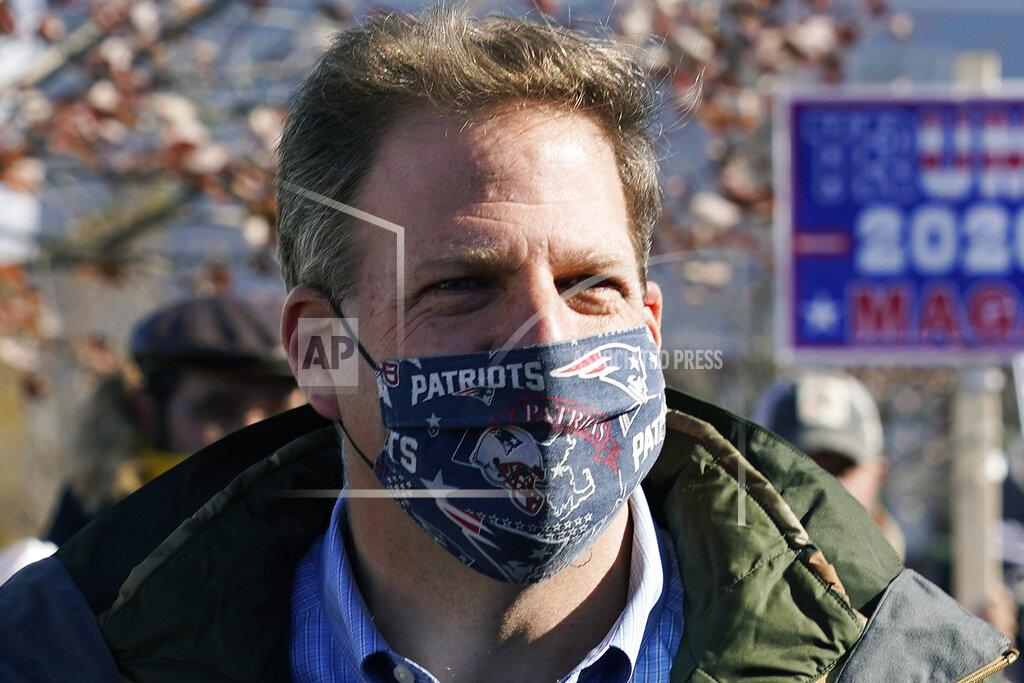 FILE - In this Nov. 3, 2020 file photograph, N.H. Gov. Chris Sununu wears a protective mask, due to the COVID-19 virus outbreak, at a polling station in Windham, N.H. New Hampshire joined three dozen other states, including the rest of New England, in enacting a statewide mask mandate as the coronavirus pandemic intensifies. Sununu issued an executive order requiring masks to be worn in public spaces, indoors or outside, when social distancing isn't possible, which goes into effect on Thursday Nov. 19, 2020. (AP Photo/Charles Krupa, File)