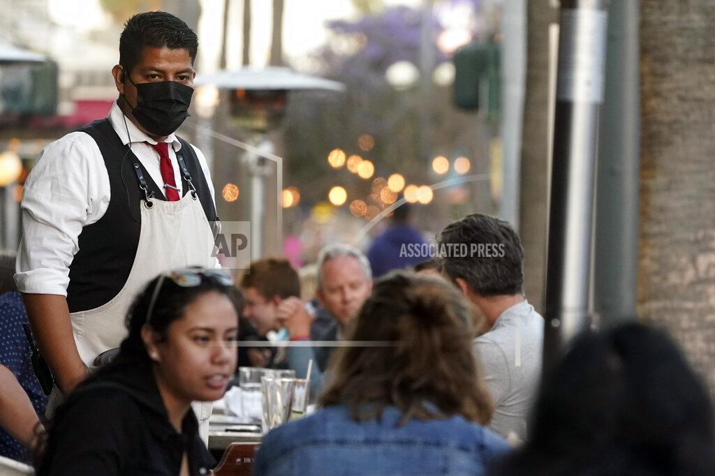 Marcio Jose Sanchez A server tends to customers in an outdoor dining area amid the COVID-19 pandemic on The Promenade Wednesday, June 9, 2021, in Santa Monica, Calif. (AP Photo/Marcio Jose Sanchez)