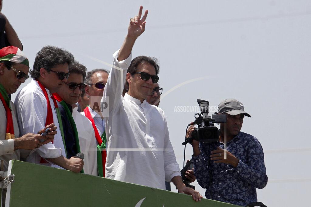 Mohammad Zubair Ousted Pakistani Prime Minister Imran Khan gives the victory sign to supporters as he leads a march toward Islamabad, in Swabi, Pakistan, Wednesday, May 25, 2022. Pakistani police have fired tear gas and scuffled with stone-throwing supporters of Khan as they gathered for planned marches Wednesday toward central Islamabad. The defiant former premier had called followers to a rally outside Parliament to bring down the government and force early elections. (AP Photo/Mohammad Zubair)