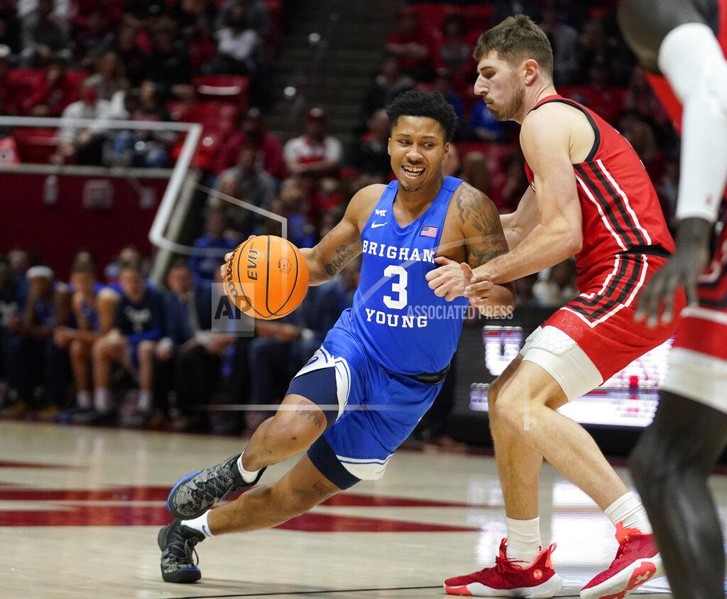 Rick Bowmer BYU guard Te'Jon Lucas (3) drives around Utah forward Riley Battin, right, in the first half during an NCAA college basketball game Saturday, Nov. 27, 2021, in Salt Lake City. (AP Photo/Rick Bowmer)