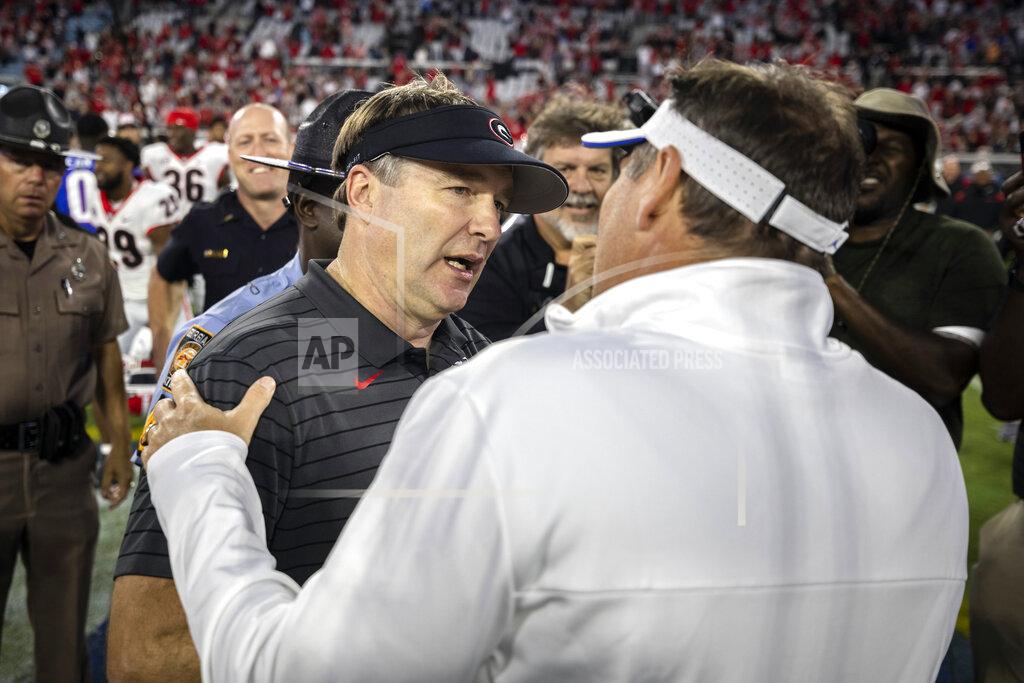 Georgia coach Kirby Smart, left, and Florida coach Dan Mullen meet after Georgia's win in an NCAA college football game Saturday, Oct. 30, 2021, in Jacksonville, Fla. (Stephen B. Morton/Atlanta Journal-Constitution via AP)