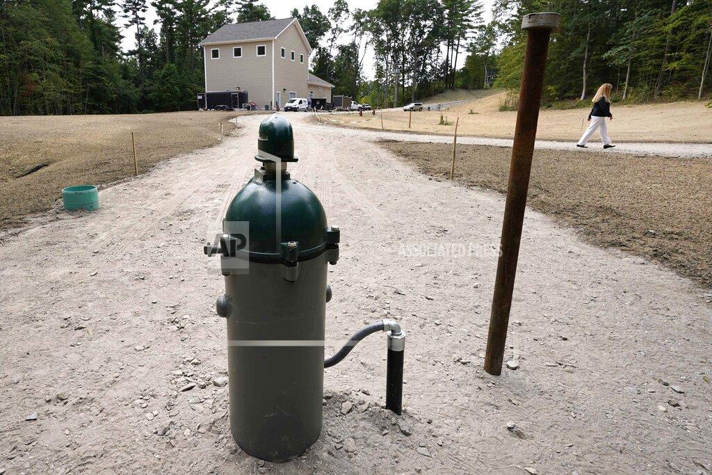 Charles Krupa In this Friday, Aug. 14, 2020, photo New Hampshire Rep. Nancy Murphy, D-Merrimack, walks through the under-construction water filtration site for two of her town's contaminated wells, which is about two miles from the Saint-Gobain plastics factory in Merrimack, N.H. (AP Photo/Charles Krupa)