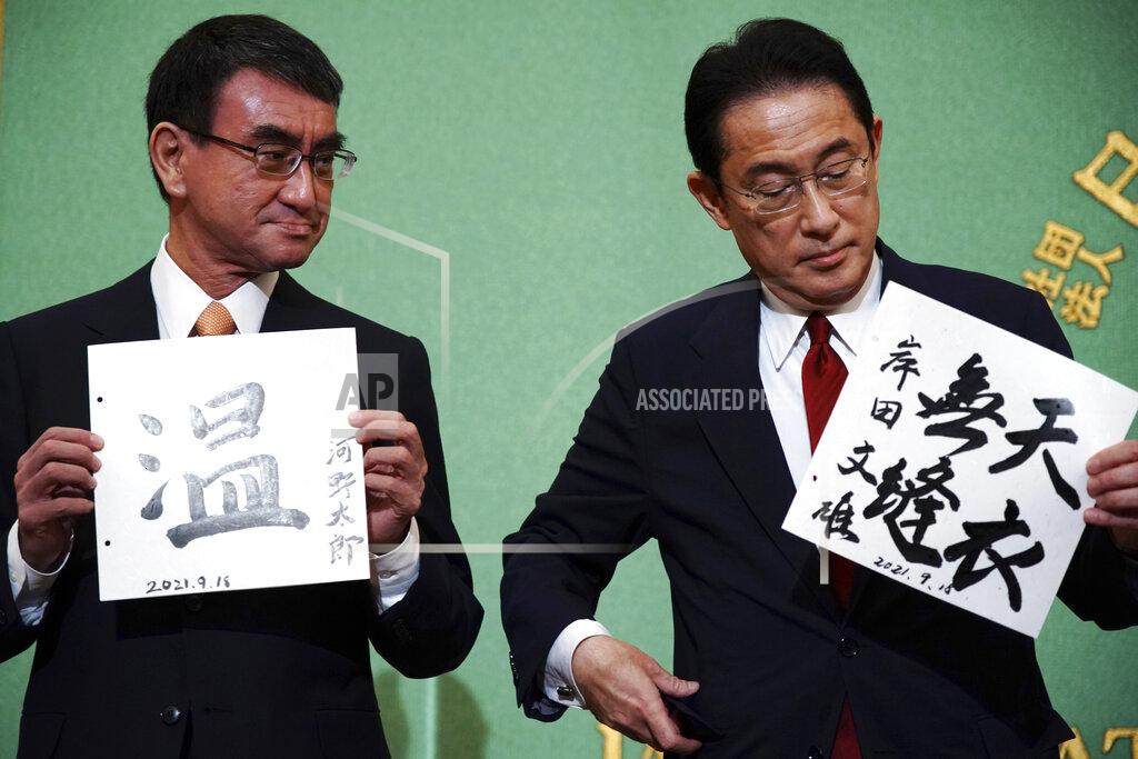 Eugene Hoshiko FILE - In this Sept. 18, 2021, file photo, Taro Kono, left, the cabinet minister in charge of vaccinations, and Fumio Kishida, former foreign minister, two of the four candidates for the presidential election of the ruling Liberal Democratic Party, pose with papers with their signs and words prior to a debate session hosted by the Japan National Press Club in Tokyo. The stakes are high as Japanese governing party members vote Wednesday, Sept. 29, 2021 for the four candidates seeking to replace Yoshihide Suga as prime minister. The next leader must address a pandemic-battered economy, a newly empowered military operating in a dangerous neighborhood, crucial ties with an inward-focused ally, Washington, and tense security standoffs with an emboldened China and its ally North Korea. (AP Photo/Eugene Hoshiko, Pool)